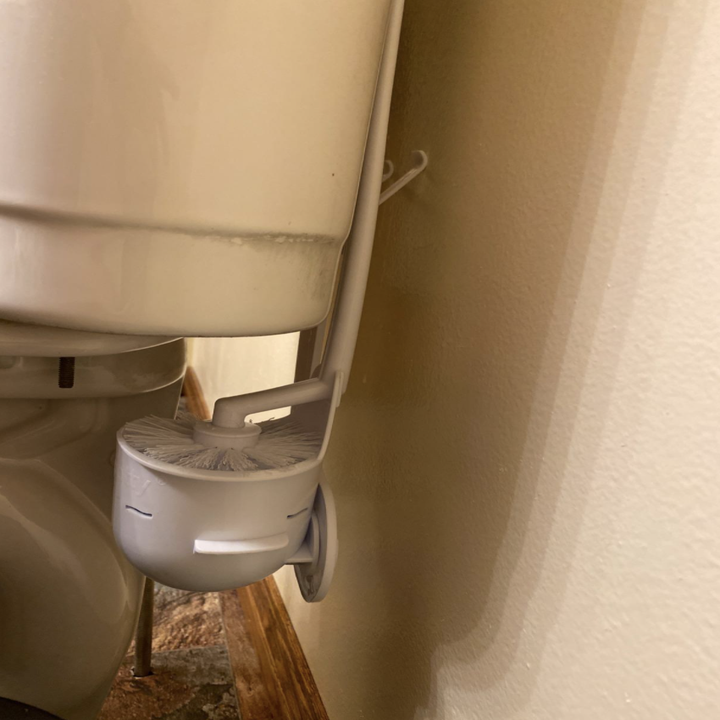 A close up of the product behind a toilet