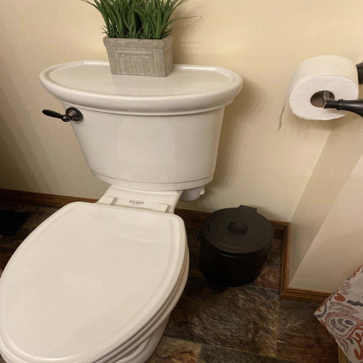 A wide shot of the product behind the toilet