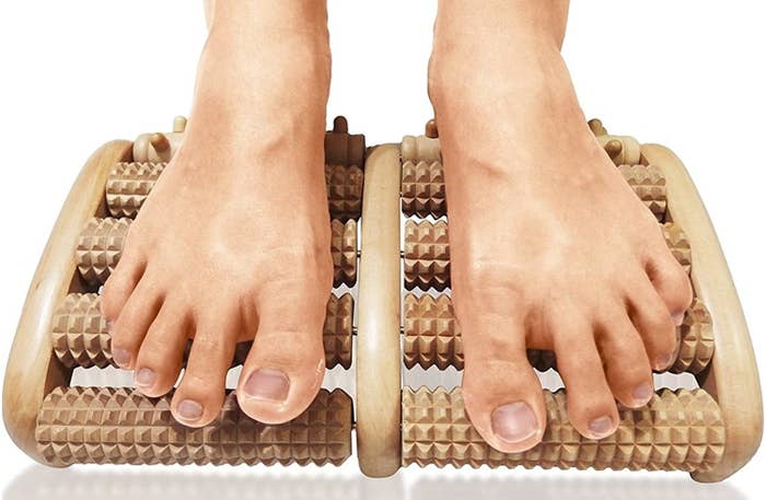 Two feet slide over a wooden foot massager