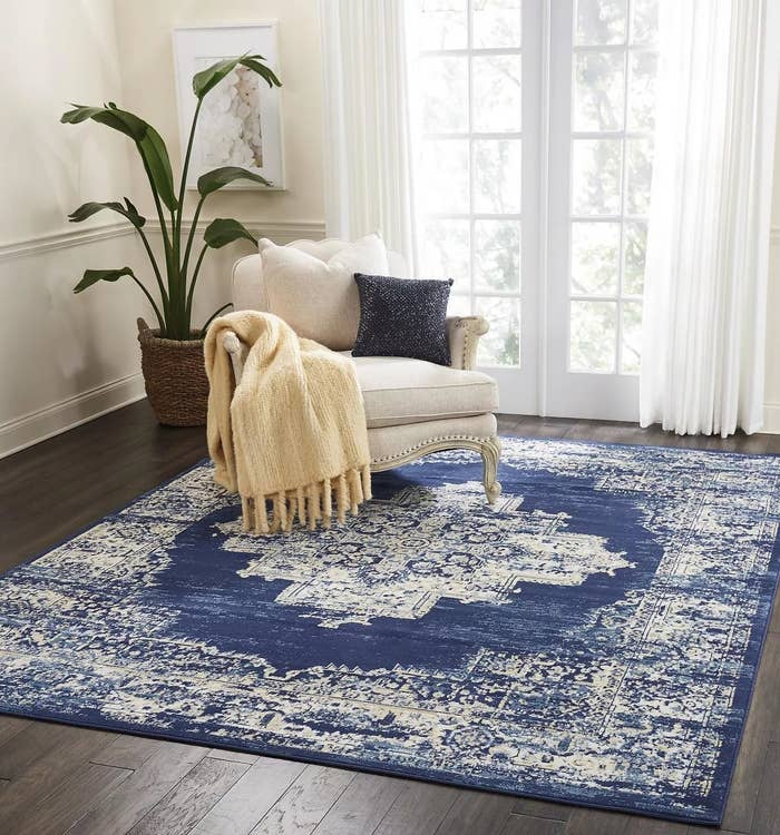 A navy and white area rug with a distressed Persian design