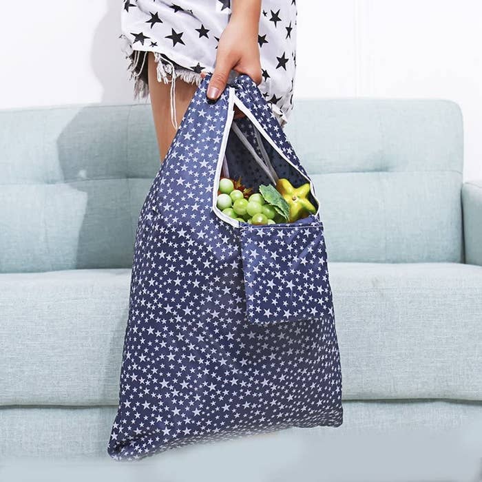 A person carrying a large reusable bag that&#x27;s filled groceries