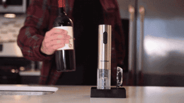 Gif of the ocular silver wine opener being put on top of a wine bottle and removing the cork in three seconds. 