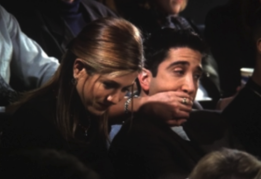 Rachel covering Ross&#x27;s mouth with her hand