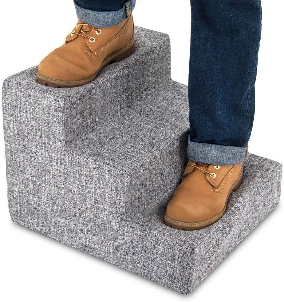 Model standing on ash grey linen set of three-step dog stairs