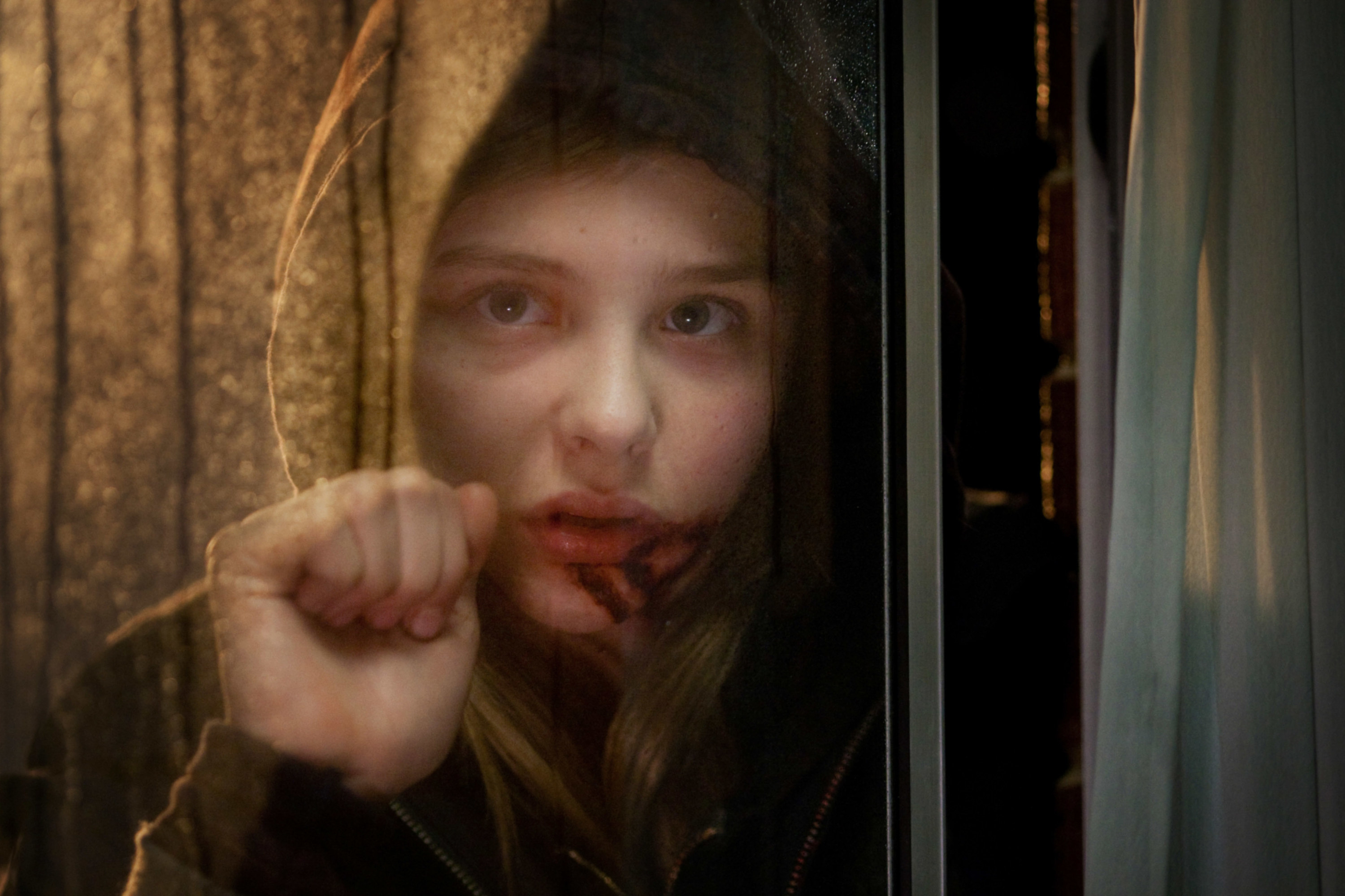 Chloë Grace Moretz knocking on a window in the movie Let Me In