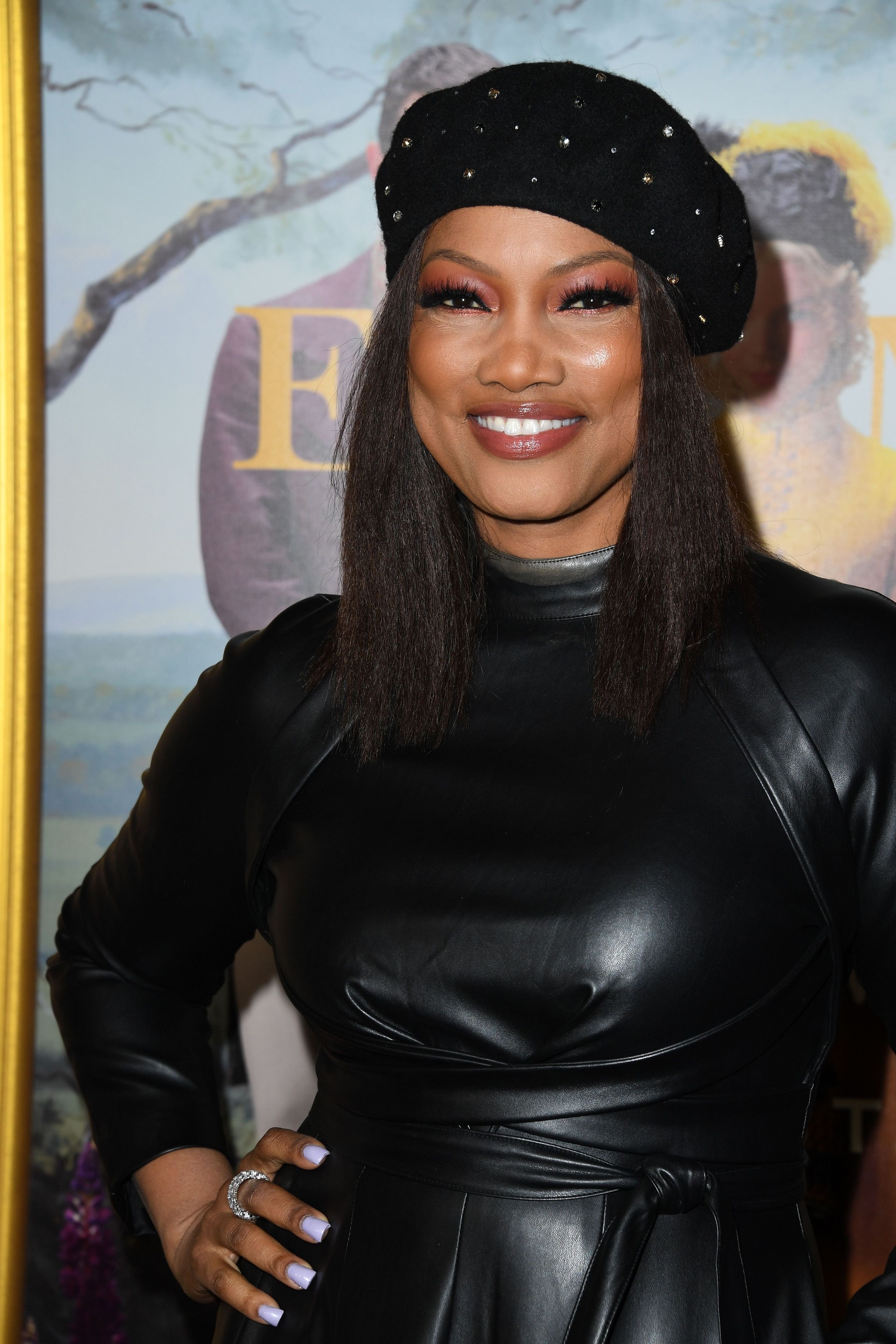 Garcelle posing with her hand on her hip wearing a dark leather outfit