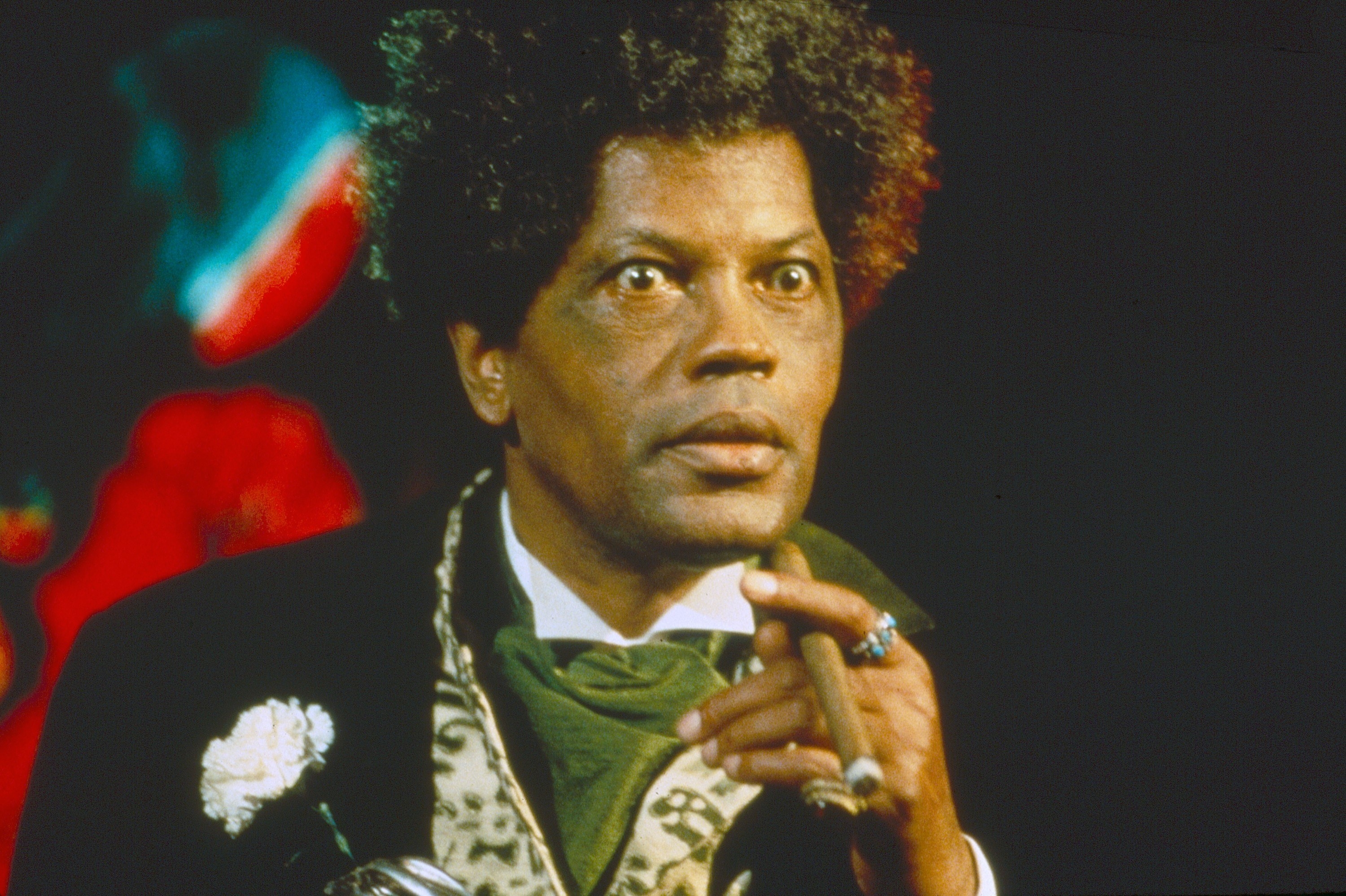 Clarence Williams III, looking ahead with a cigar in one hand