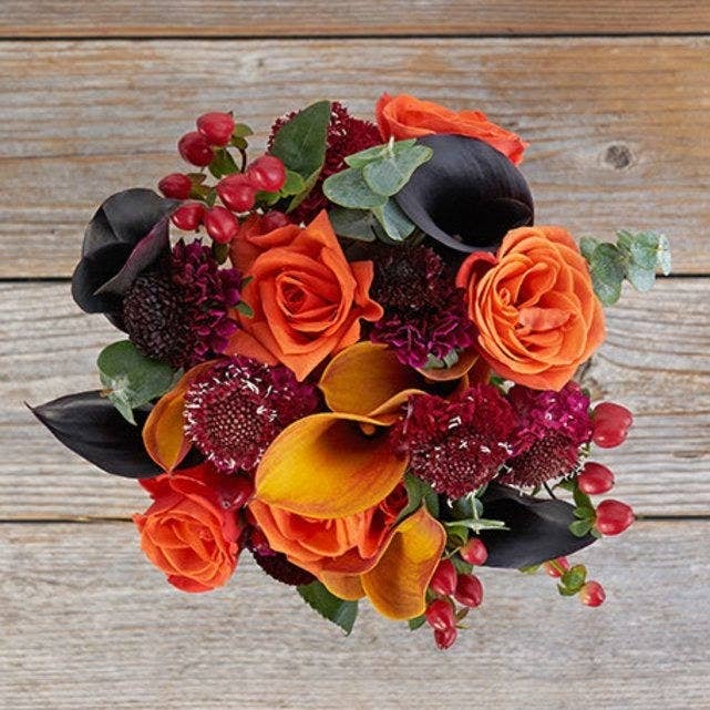A fall-inspired orange and dark purple bouquet