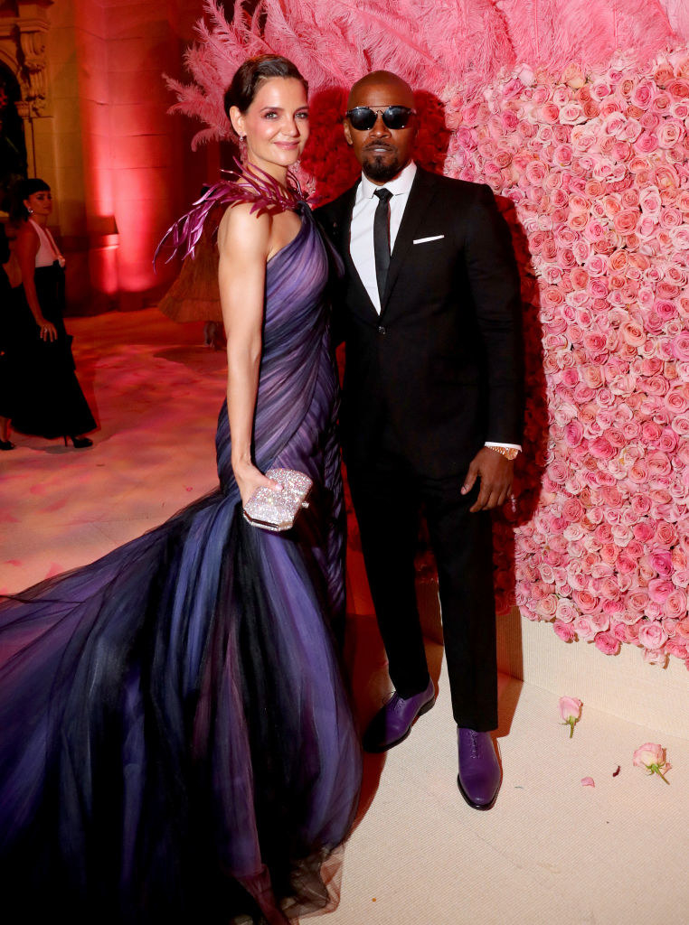 Katie Holmes wearing a poofy dress and Jamie Foxx in a dark suit at an event