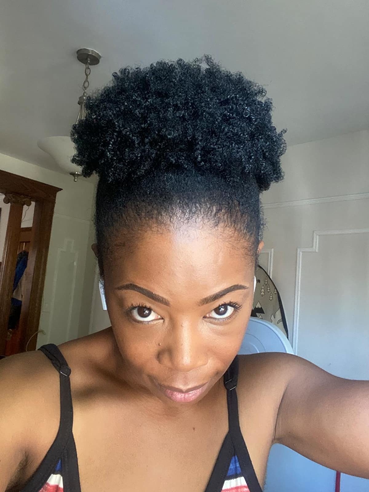 A reviewer with 4C hair styled in a puff