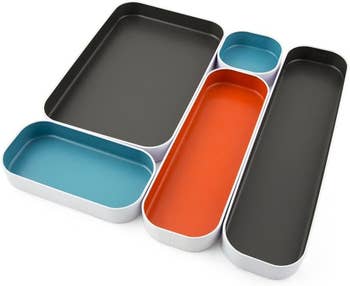 The different size trays in gray, orange, and blue