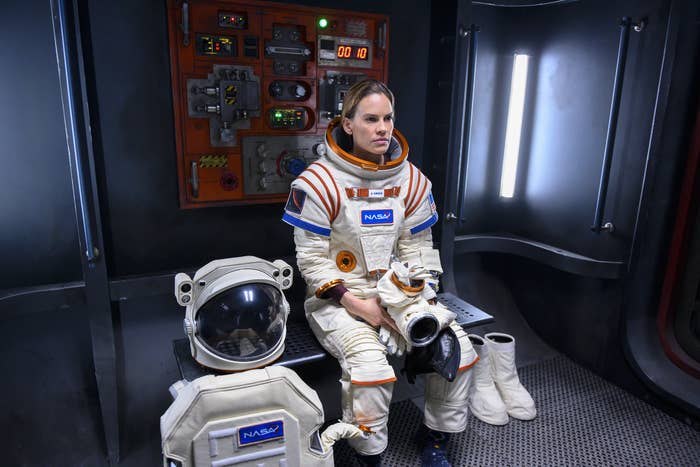 Hilary Swank sitting down with her space gear on, in the show Away