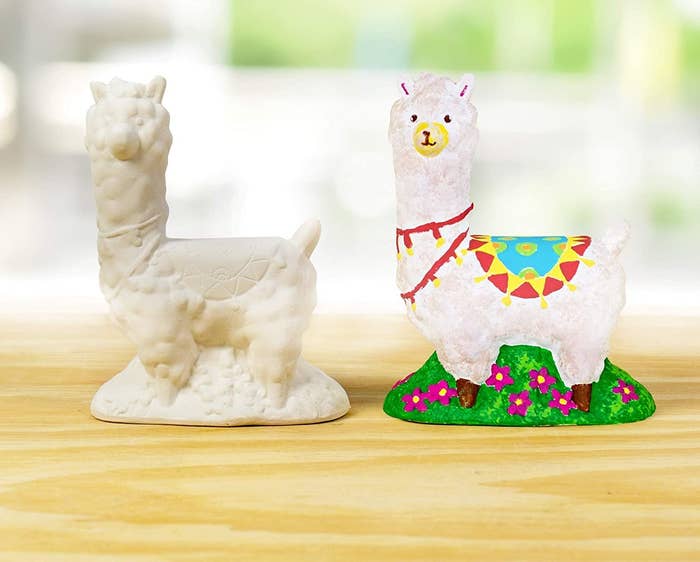 An unpainted ceramic llama beside a painted one