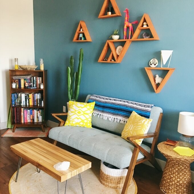 The light blue loveseat with geometric wooden arms and legs