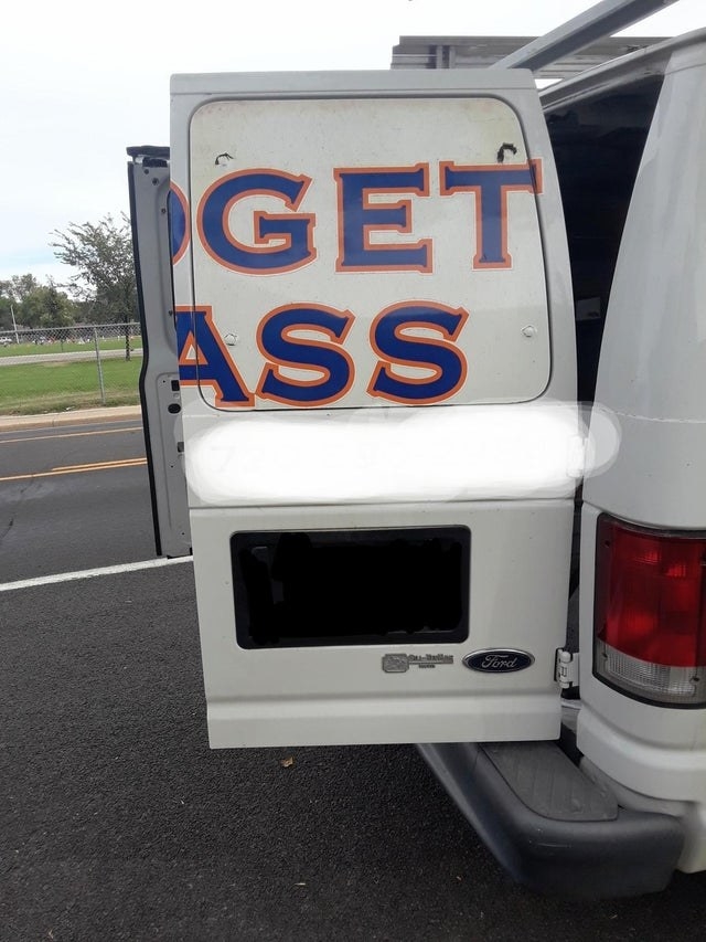 a van has its doors open and the text on one of the doors unfortunately reads get ass