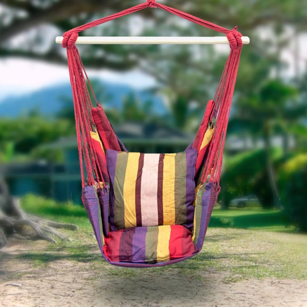 A hanging hammock chair in rainbow colors outside