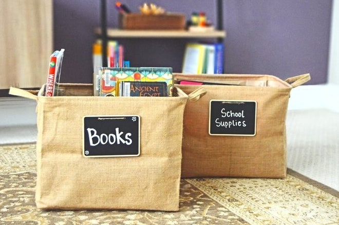 Two of the bins — one is labeled as books and is holding books, and the other is labeled as school supplies