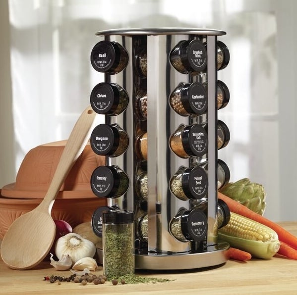 The spice rack filled with the various spices — the lids for each one are labeled with the name of the spice that&#x27;s inside of it