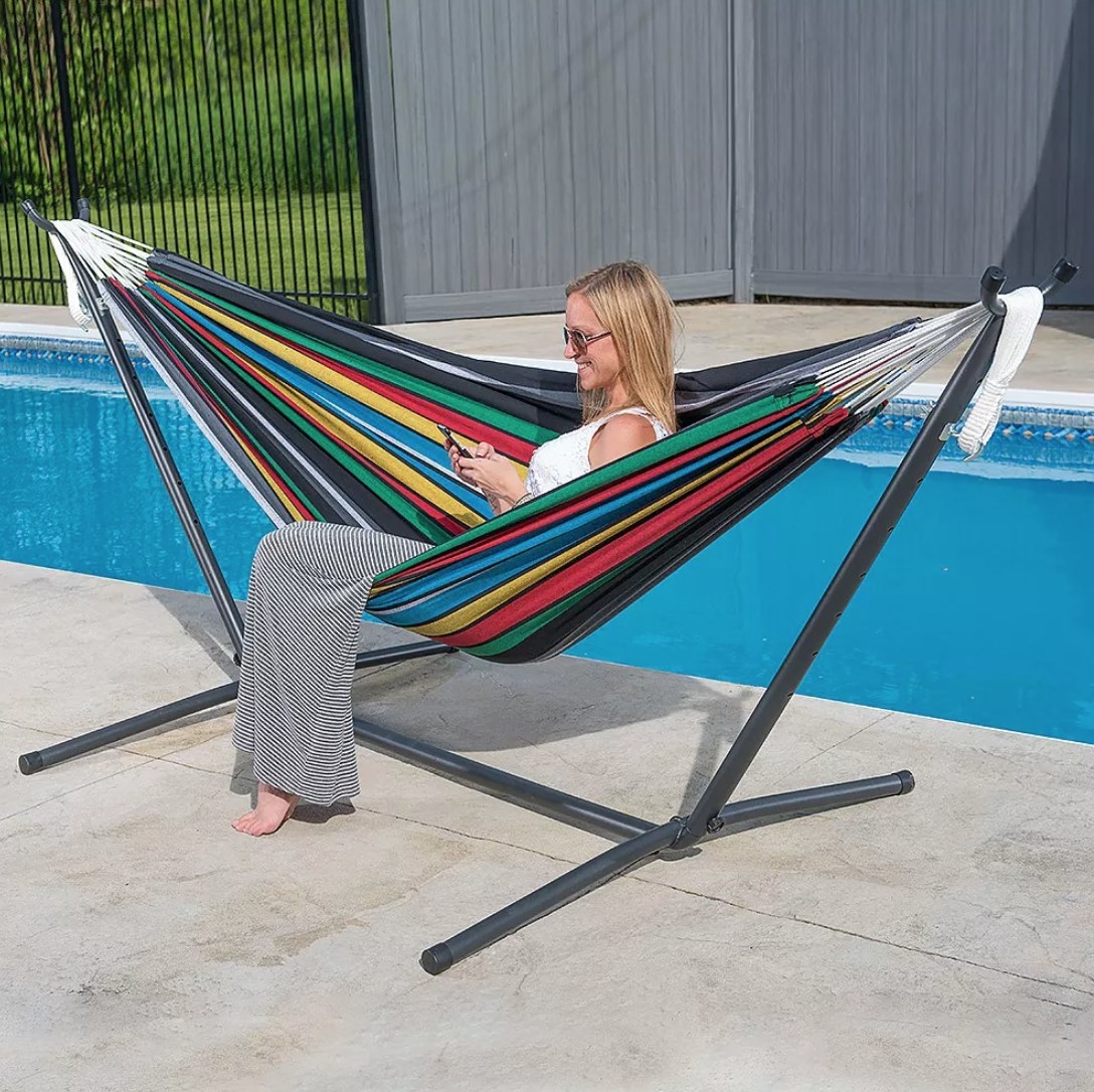 A rainbow hammock held up by a metal stand