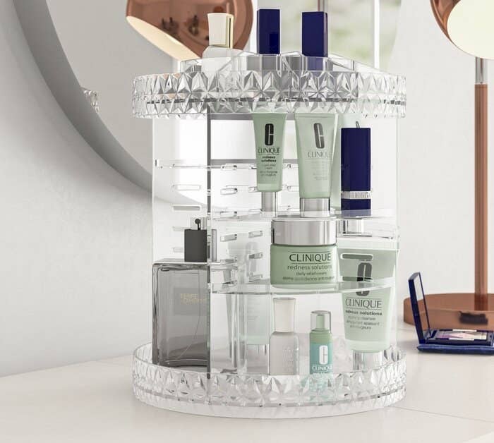 The rotating organizer in clear holding various makeup and skincare products, as well as perfumes