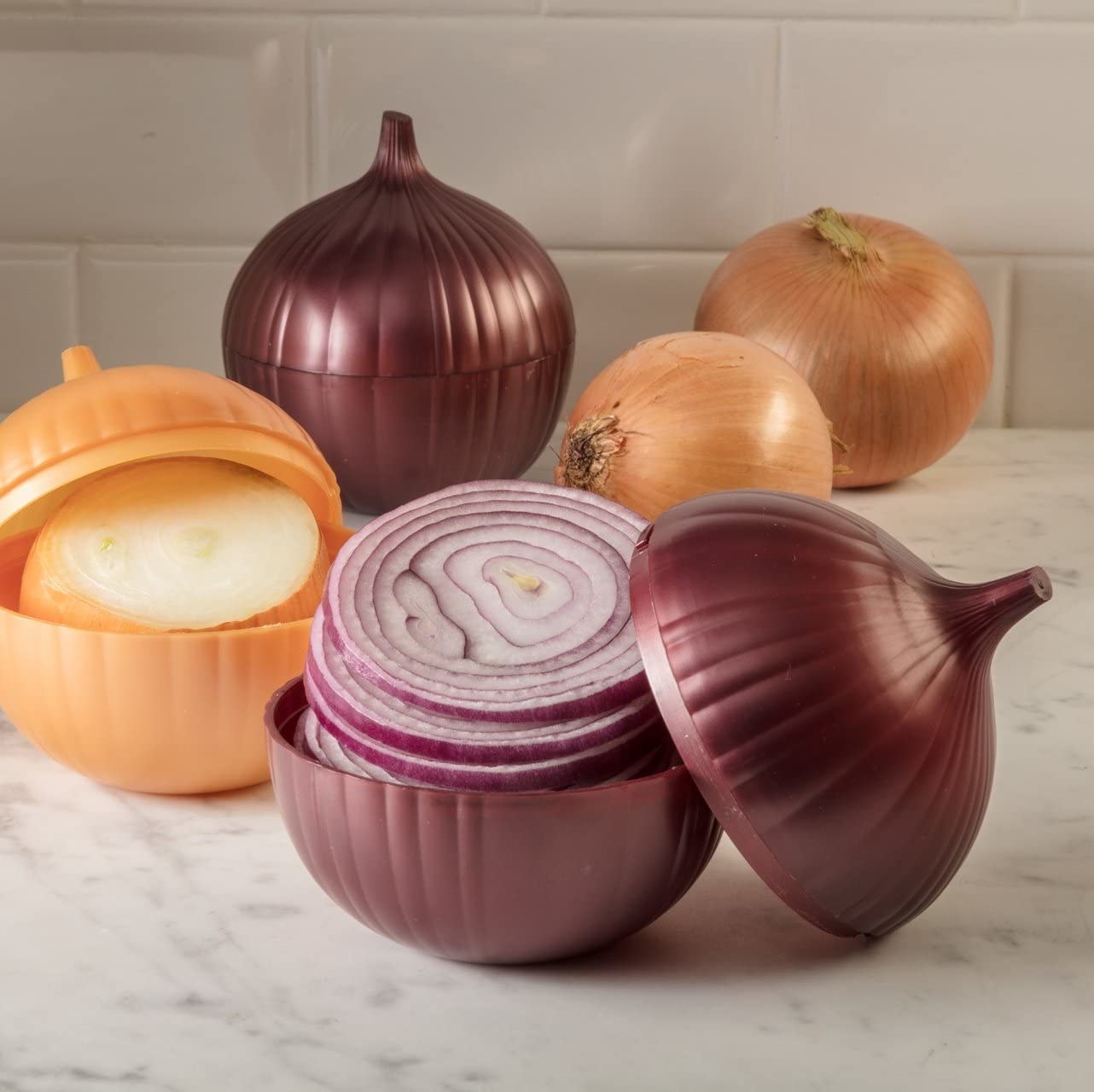 The onion saver tipped open on a counter to show the red onion inside