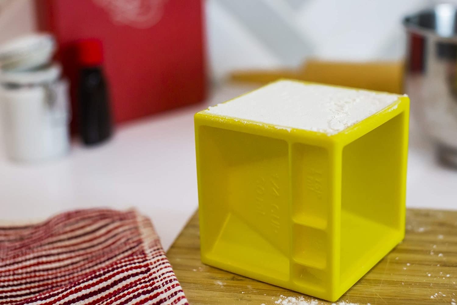 A yellow measuring cube with grooves measuring a 