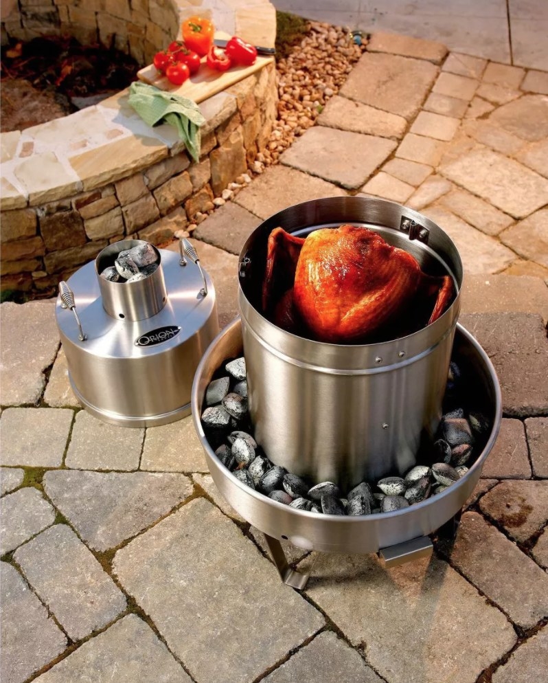 A stainless steel outdoor cooking apparatus with a turkey in it