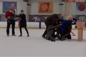 a bunch of people trying to push a woman up onto a wooden platform
