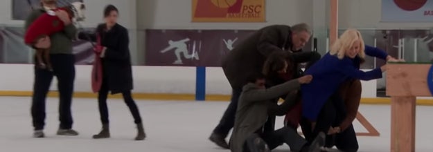 a bunch of people trying to push a woman up onto a wooden platform