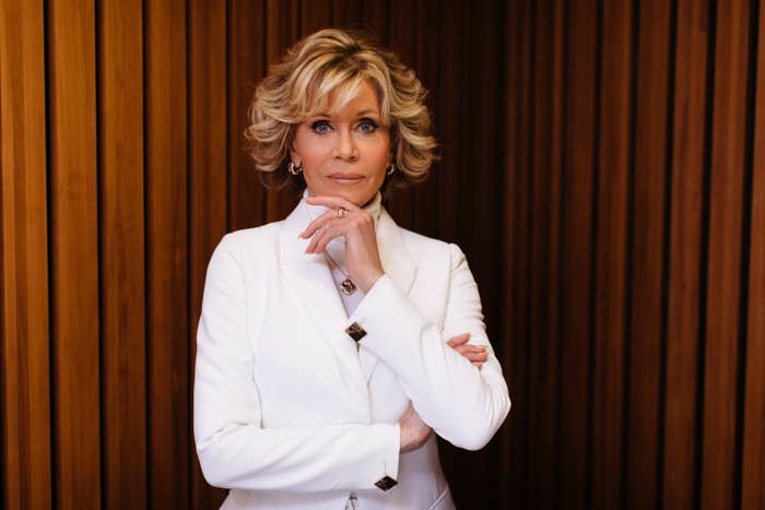 A photo of Jane Fonda looking pensive at directly at the camera while wearing a white suit in 2018