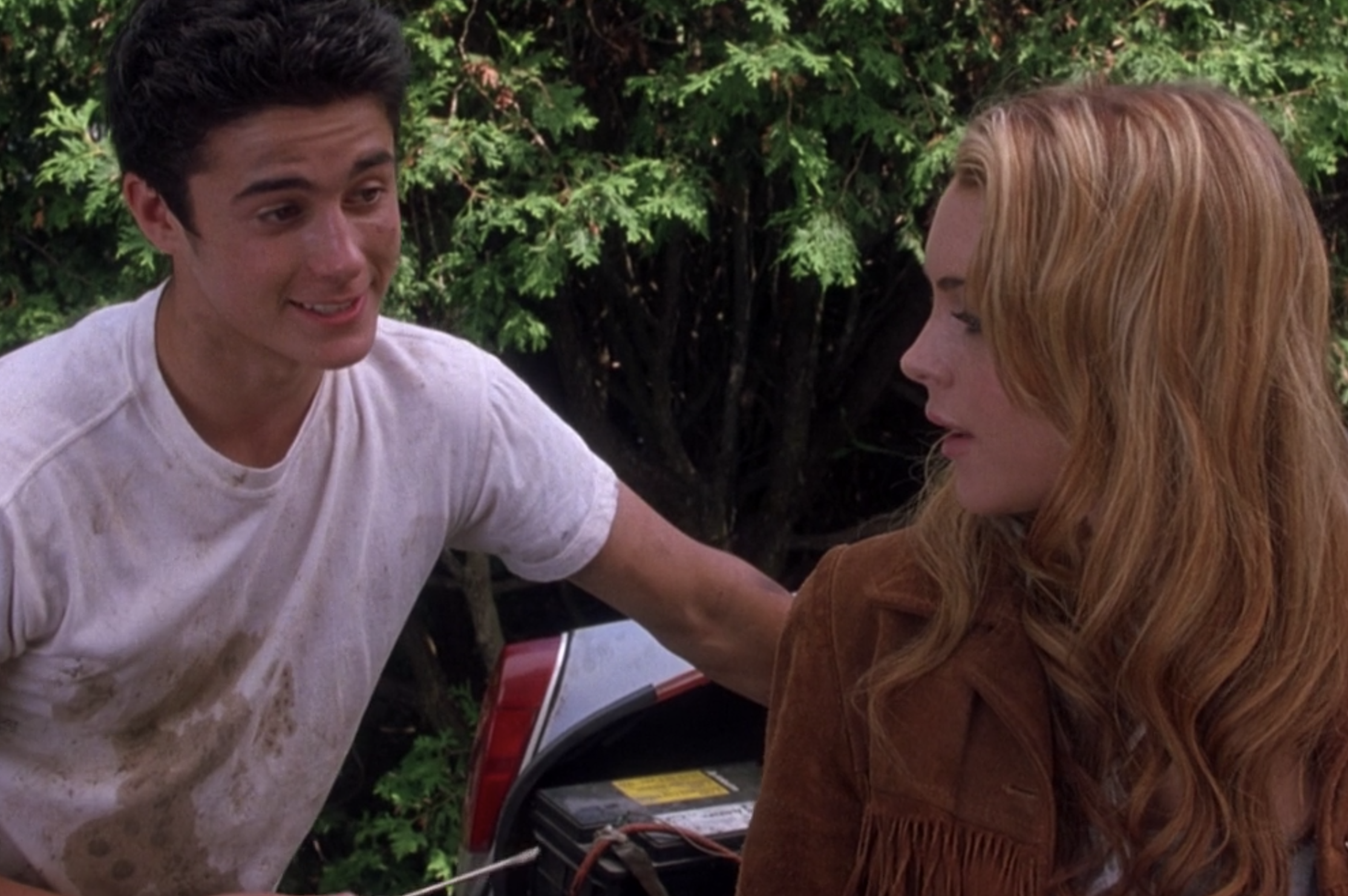 Eli Marienthal stands next to Lindsay Lohan as Lola and her car in a grease-stained shirt as Sam in &quot;Confessions of a Teenage Drama Queen&quot;