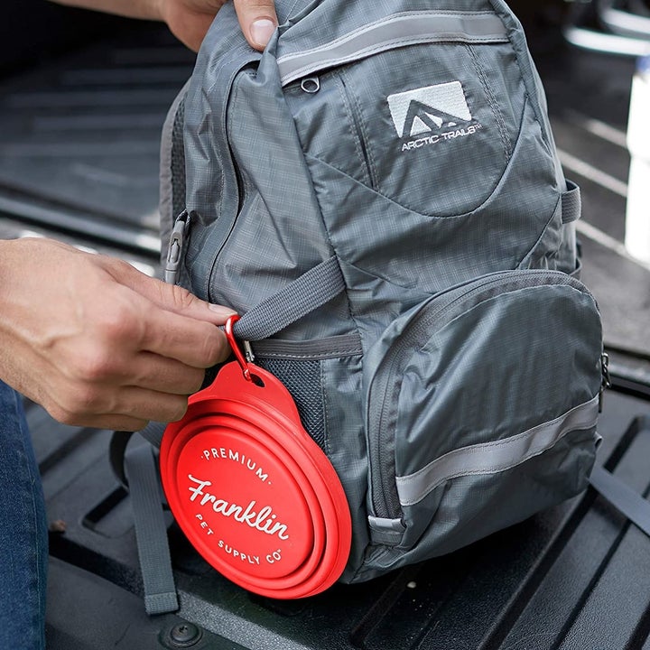 The collapsed bowl attached to a backpack