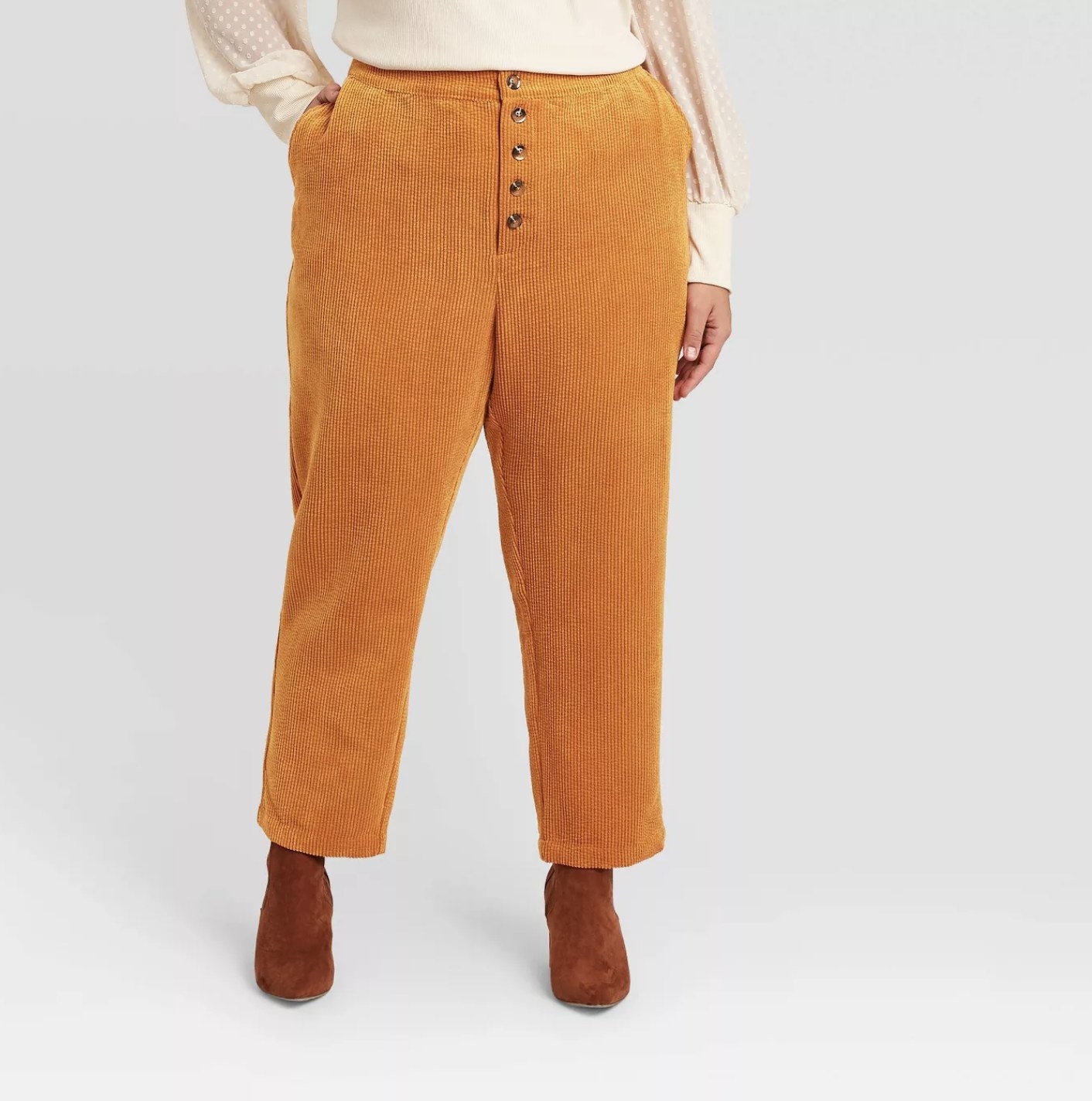 Model is wearing orange corduroy pants