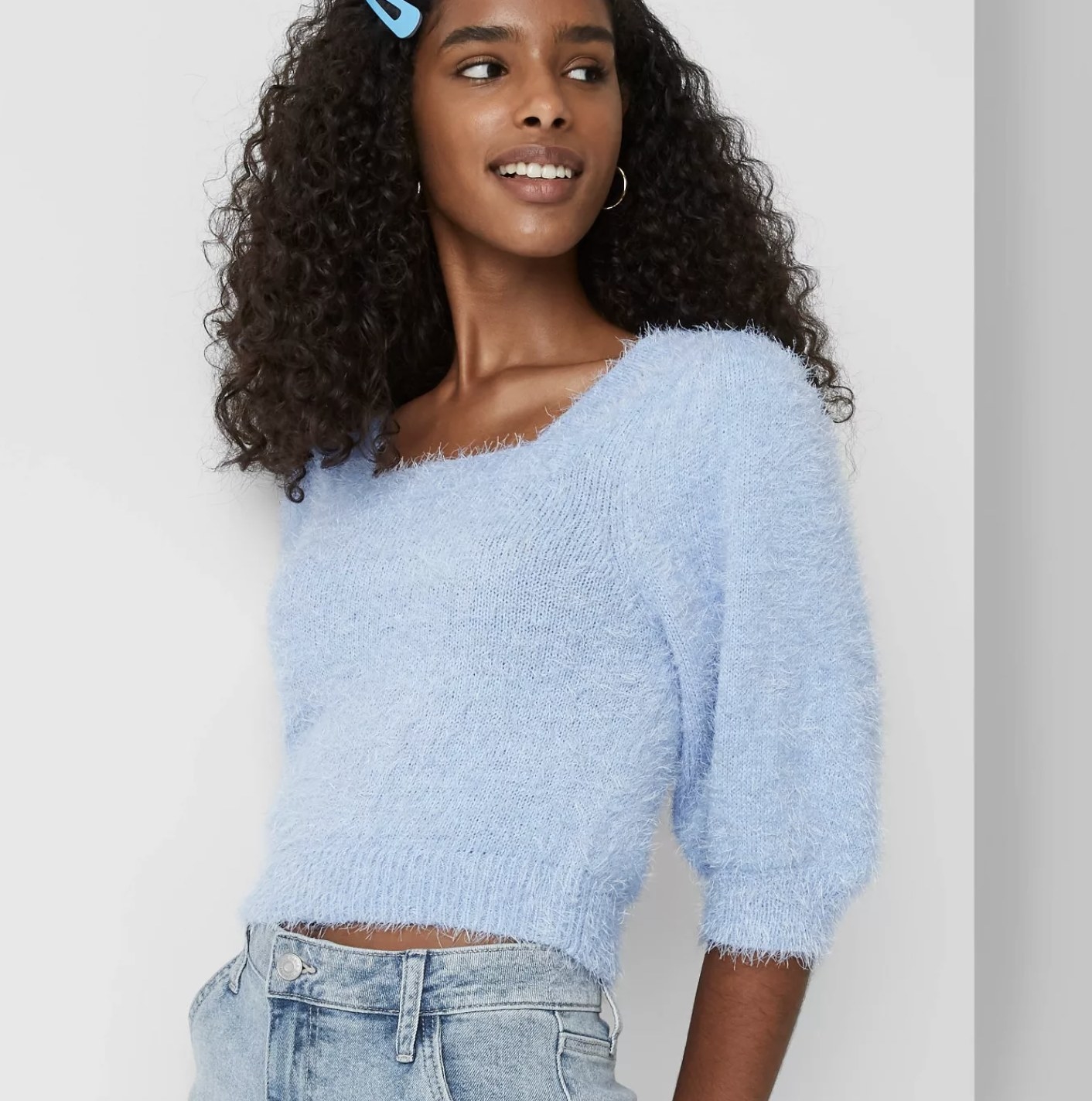 Model is wearing a light blue fuzzy cropped sweater with a square neckline 