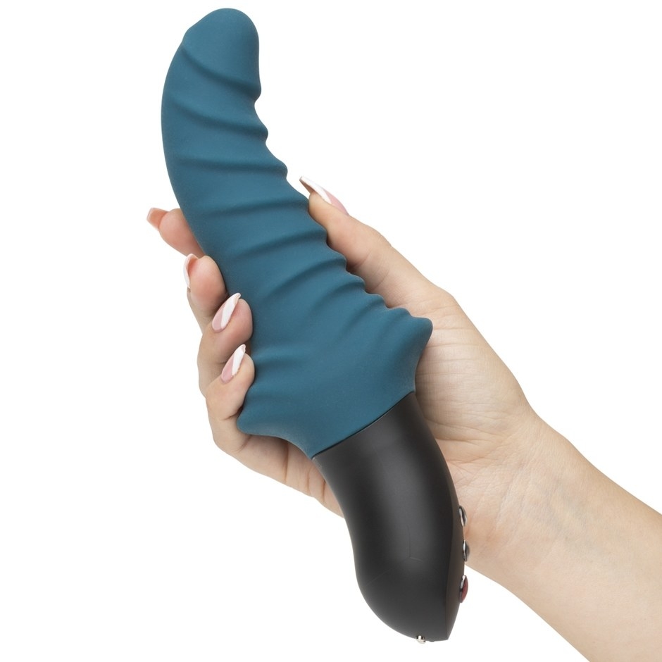 The blue Fun Factory X Lovehoney Stronic Drei Rechargeable Powerful Thrusting Vibrator in a model's hand