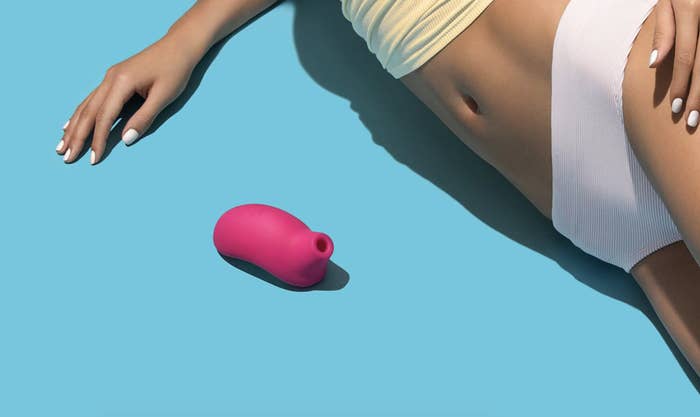 The LELO SONA sonic clitoral massager next to a model's body
