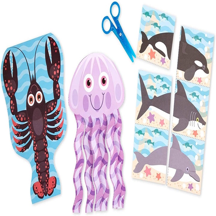 The full kit which includes three sea animal pages pulled out of the book (a lobster, jellyfish, and sharks), and the plastic scissors
