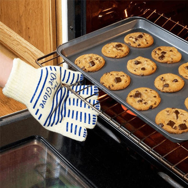 person using ove glove to pull oven shelf out of oven