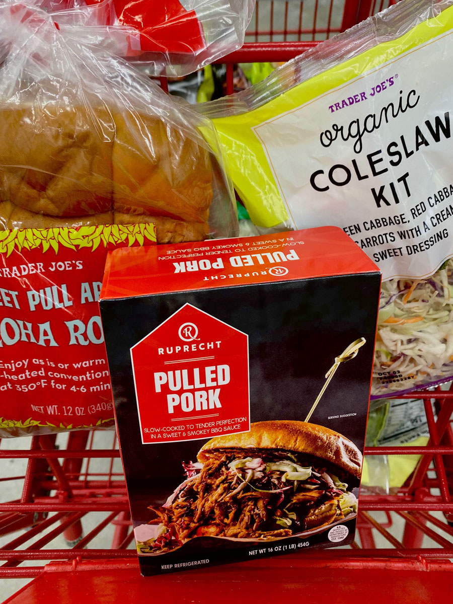 Pulled pork, aloha rolls, and coleslaw kit in a shopping cart.