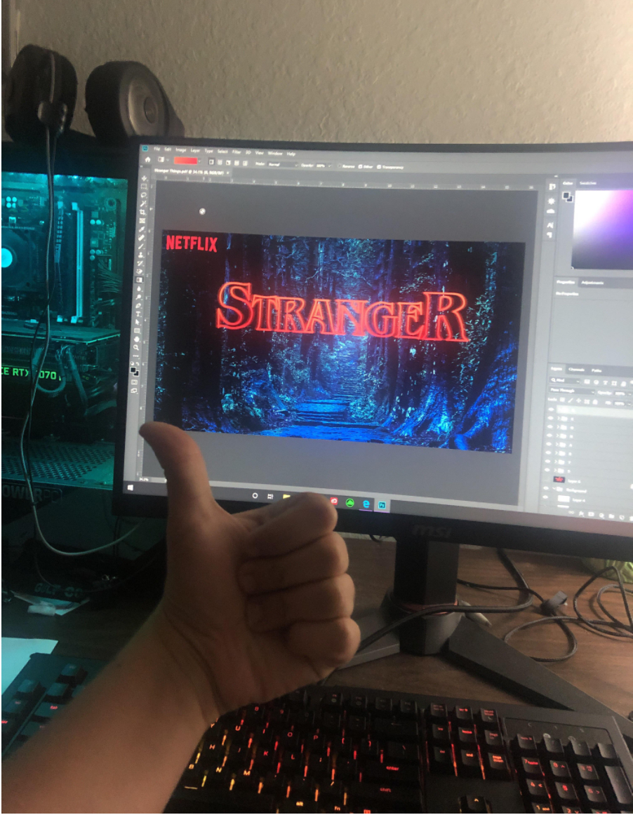 A kid gives a thumbs up as he edits a fake Stranger Things promo on his computer