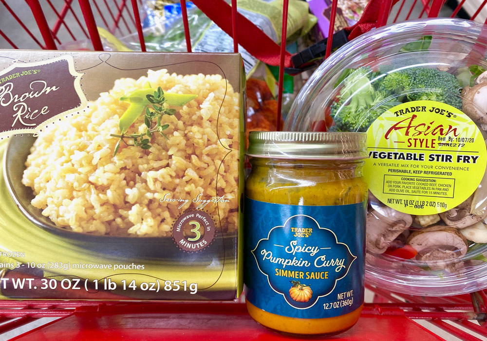 Frozen brown rice, spicy pumpkin curry simmer sauce, and Asian style vegetable stir fry in a shopping cart.