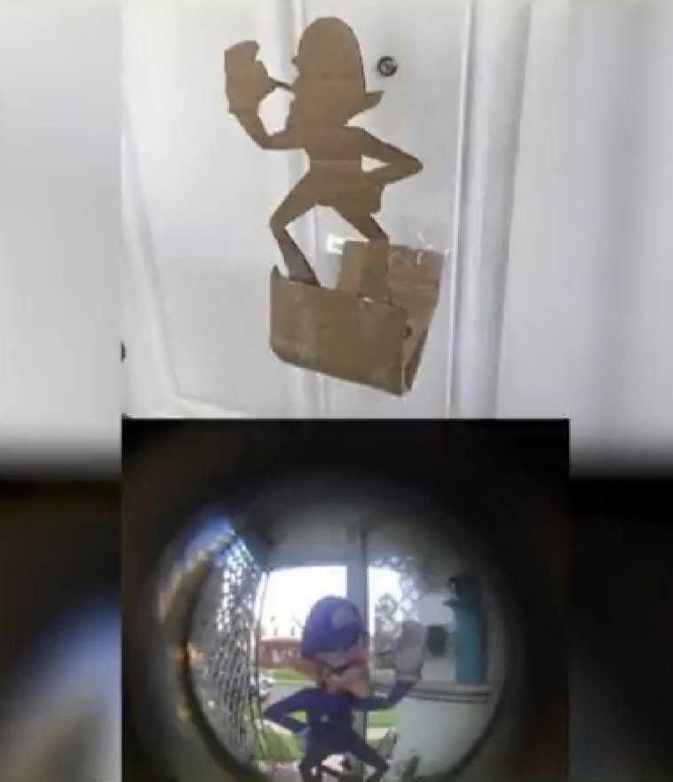 A cardboard cutout of a Nintendo character has been put over the eyehole making it look like the character is just outside