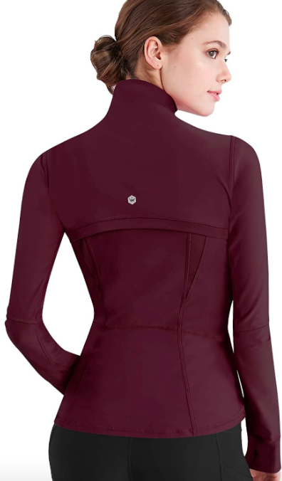 Model wears wine-colored running zip-up shirt with black leggings