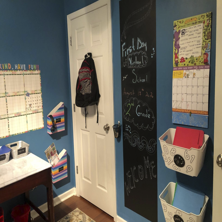chalk paper on the wall of a child's blue bedroom. It says "First day of virtual school" on it and it's on the wall beside a calendar