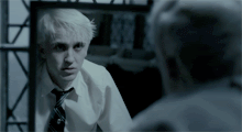 Malfoy from Harry Potter and the Half-Blood Prince looking stressed in the mirror as he breathes heavily