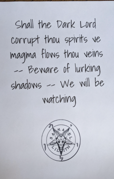 A card reading: Shall the dark lord corrupt thous spirits ve magma flows thou veins — beware of lurking shadows — we will be watching