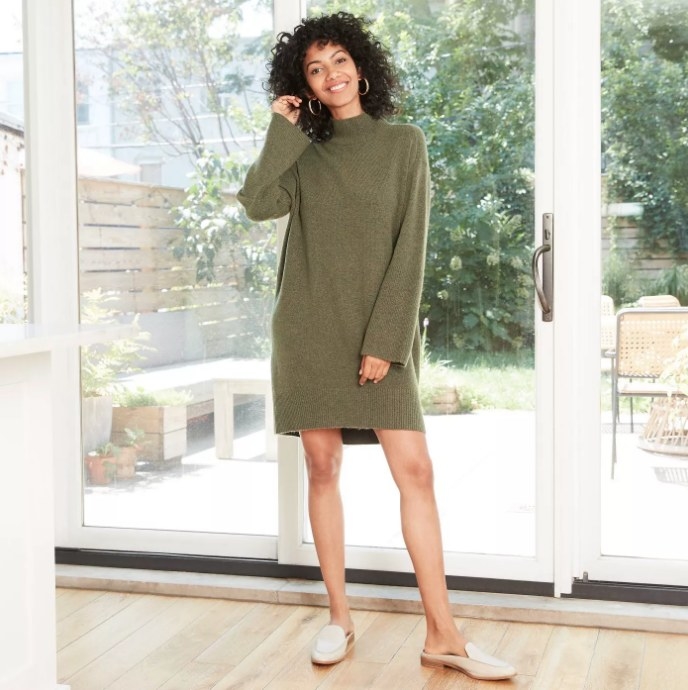 Model wearing green sweater dress with white loafers