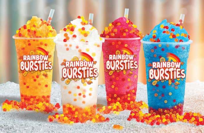 Collection of Hungry Jack&#x27;s frozen drinks with rainbow bursties both in the drinks and on the icy ground