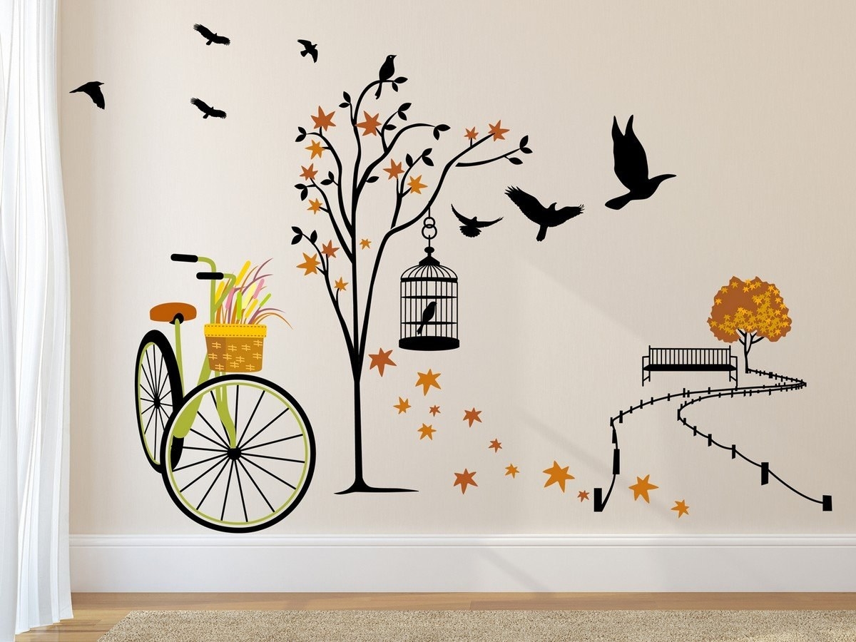 A wall decal with a bicycles, trees with browning leaves and birds