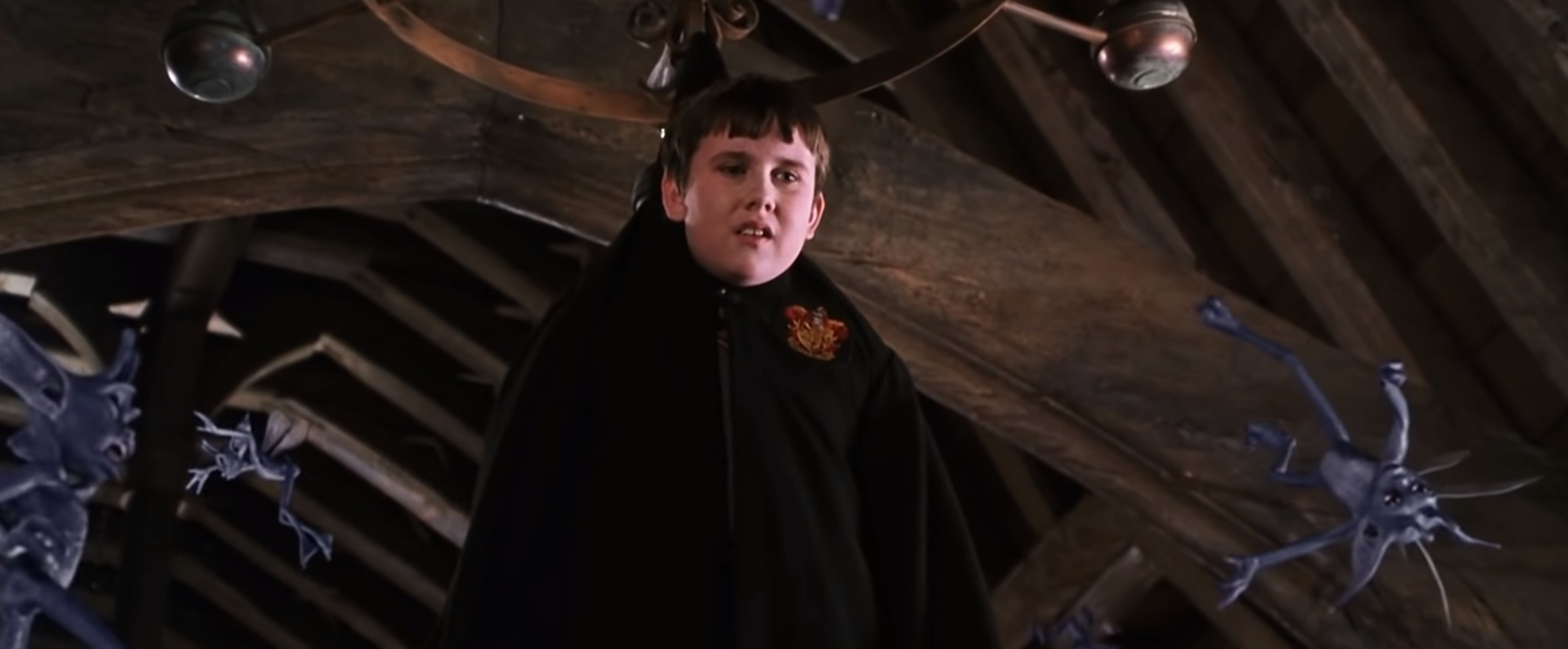 Neville hanging from the Defense Against the Dark Arts chandelier surrounded by Pixies 